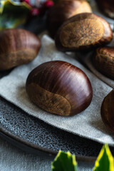 Step by step process of making roasted chestnuts. Heap of raw chestnuts on linen cloth.