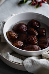 Step by step process of making roasted chestnuts. Chestnuts soaked in water before baking.
