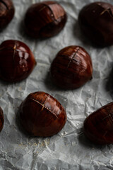 Step by step process of making roasted chestnuts. Previously soaked in water chestnuts with cuts on baking  paper before roasting.