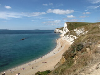 the beautiful english jurassic coast with white cliffs and a beach and the south west coast path in summer