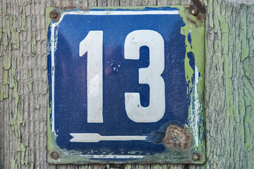 Weathered grunge square metal enameled plate of number of street address with number 13