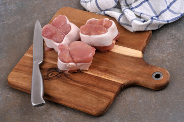 Paupiettes de veau crues sur une planche à découper avec un couteau et un torchon