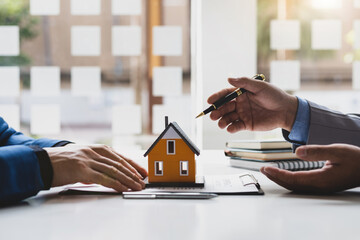 Real estate agent is discussing and explaining the terms of the home purchase contract. Businessman...