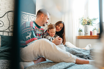 Obraz na płótnie Canvas Happy family near fir-tree in bedroom, Christmas celebration at home