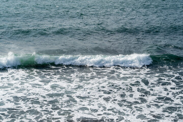 Waves in traditional turquoise, green, gray tones as perfect backdrop for festive theme. Sea waves near shore. Close-up of foamy waves. Elegant nature concept for design