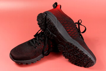 Black and red sport shoes theme in red color background. Pair of tennis shoes - Powered by Adobe