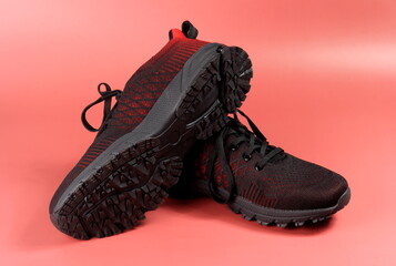 Black and red sport shoes theme in red color background. Pair of tennis shoes