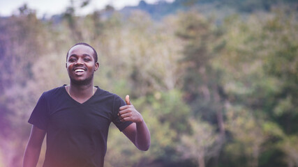 African man standing in nature forest and lake with smile and happiness.Concept about nature fertility and relaxation
