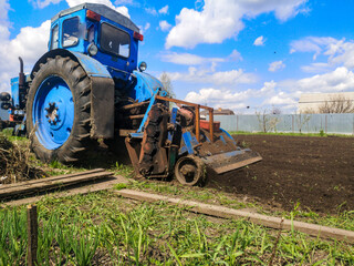Obraz premium The tractor plows the soil on the field