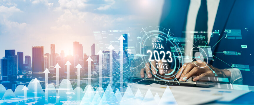 Smart businessman pointing digital dashboard in 2022 on hologram blue background.Artificial intelligence (AI),machine learning support for enhancing business growth.Futuristic technology trend concept