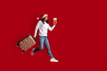Black woman tourist in Santa hat running towards copy space