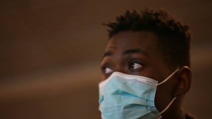 Commuter black man wearing covid-19 face mask going up the electric staircase