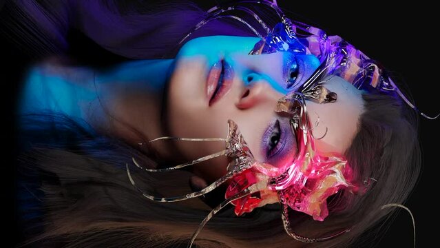 Gorgeous brunette with a fantastic transparent 3d mask. Bright makeup, shining eye shadow. Beautiful styling and makeup, glamorous diva