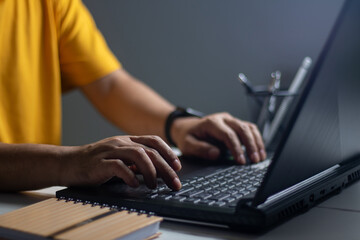 Male hands sitting overtime at the office on laptop at night