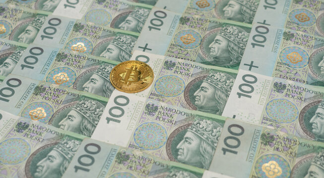 Złotówki, polski złoty, gotówka, Bitcoin cash (BTC)  cryptocurrency pictured as a gold coin lying over cash polish złoty (polish currency)
