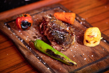Grilled steak on a wooden plate
