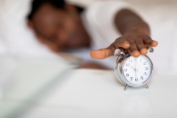 Closeup Shot Of African American Man Turning Off Alarm Clock With Hand