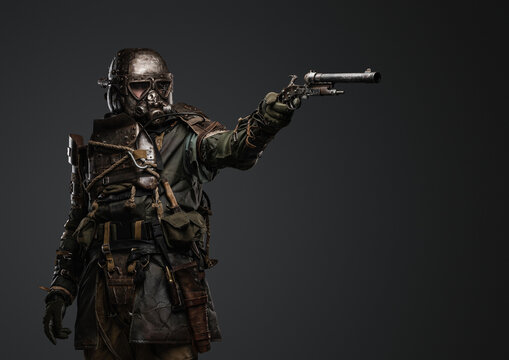 Shot of isolated on grey background soldier in setting of post apocalypse aiming pistol.