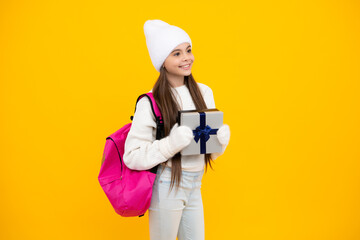 Portrait of teenager child girl 12, 13, 14, years old holding Christmas gift box. Teen giving birthday gift.