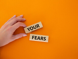 Your fears symbol. Wooden blocks with words Your fears. Beautiful orange background. Businessman hand. Business and Your fears concept. Copy space.