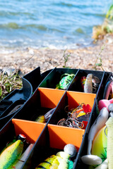  Fisherman's tackle box fully stocked with lures and gear for fishing. 