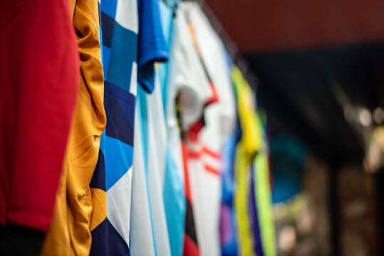 Soccer Jerseys Are Hanging In A Row In A Retail Store.