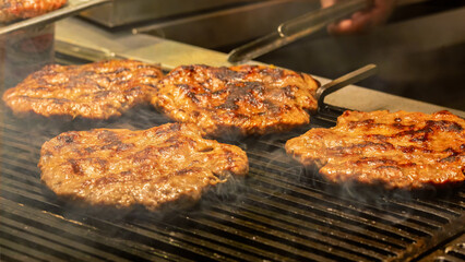 Cooking smoked burgers on hot grill. Street food concept
