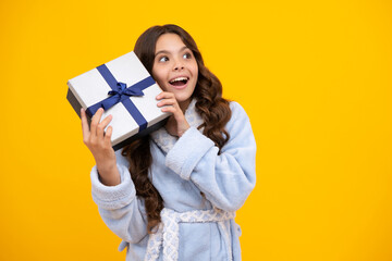 Amazed teen girl. Emotional teenager child hold gift on birthday. Funny kid girl holding gift boxes celebrating happy New Year or Christmas. Excited expression, cheerful and glad.