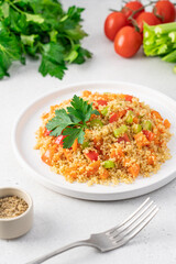 Quinoa with vegetables in a plate on a white background. Celery, carrots, paprika, tomato, parsley and quinoa seeds. Healthy diet balanced nutrition concept