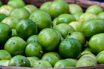Green lime fruits on the bamboo basket.