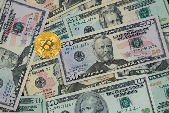 Bitcoin cash (BTC), cryptocurrency pictured as a gold, gold coin lying over dollars, real US money, 50 dollars, United States fifty-dollar bill