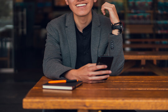 Focused man using smartphone in cafe - Powered by Adobe