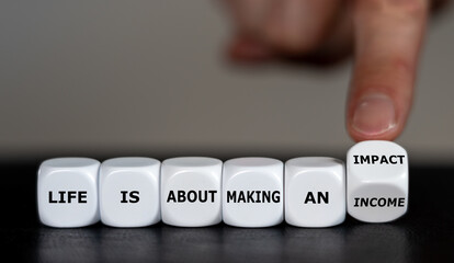 Hand turns dice and changes the expression 'life is about making an income' to 'life is about...