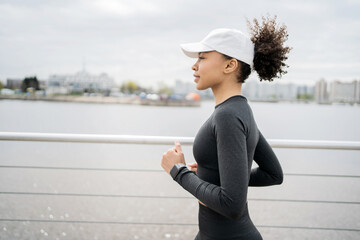 Athletic lifestyle a woman runs in the city cardio endurance training. Comfortable sports clothes...