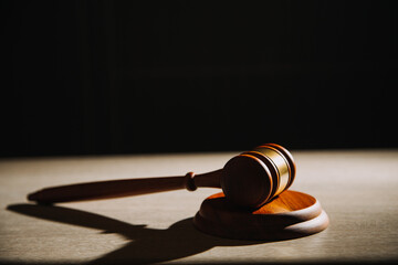 Justice and law concept.Male judge in a courtroom with the gavel, working with, computer and docking keyboard, eyeglasses, on table in morning light