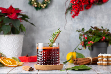 Naklejka na ściany i meble Mulled wine in glasses on white wooden table. Hot winter drink with wine, spices and fruit in Christmas decoration.