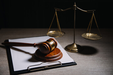 Justice and law concept.Male judge in a courtroom with the gavel, working with, computer and docking keyboard, eyeglasses, on table in morning light