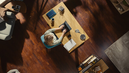 Top View of Home Office: Freelance Entrepreneur Sitting at Desk, Using Laptop. Female Professional...