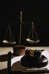 Justice and law concept.Male judge in a courtroom with the gavel, working with, computer and docking keyboard, eyeglasses, on table in morning light