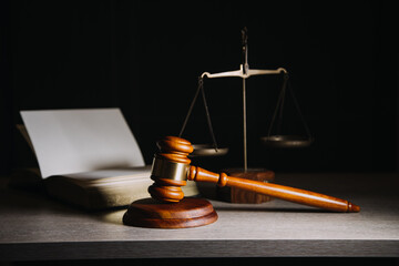 Justice and law concept.Male judge in a courtroom with the gavel, working with, computer and docking keyboard, eyeglasses, on table in morning light