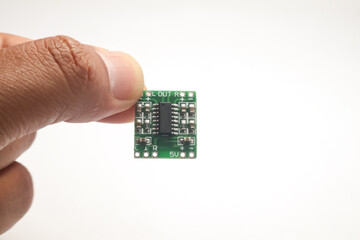 A small audio amplifier module held in one hand is used as DIY material for the electronics...