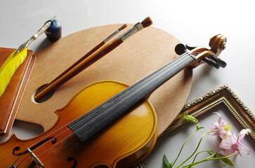 Fototapeta premium Painting, music, literature. Artist palette, brushes, violin, pipe, notepad, fountain pen, inkwell on a light background.