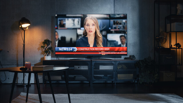 Stylish Loft Apartment Interior with TV Set with Evening News Show on Display. Monitor Standing on Television Stand. Empty Cozy Living Room of Spacious Flat with Female Presenter Reporting on Screen.