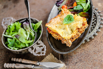 lasagnes fait maison avec salade sur table en métal 