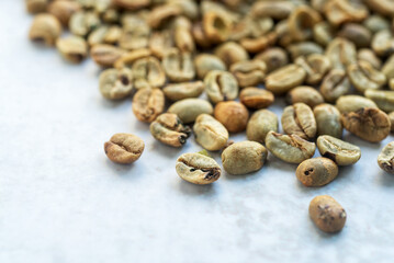 a pile of green bean coffee defect on marble background