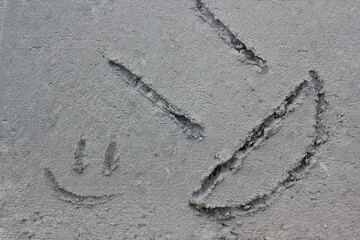 A smile scratched into concrete in black and white.