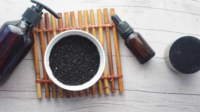 Black Cumin in a container and oil on table 