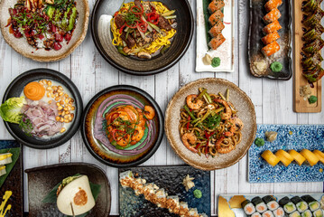 Japanese-Peruvian gastronomic fusion with ceviche, bao bread, prawn stew, udon noodles stir-fried with prawns and other typical and colorful recipes with corn and peppers