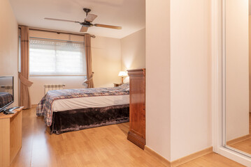 bedroom with a double bed with dark wood furniture and a built-in wardrobe with white sliding doors