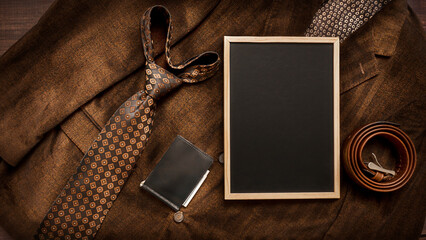 Men's necktie and accessories on Brown background with chalkboard with place for text.